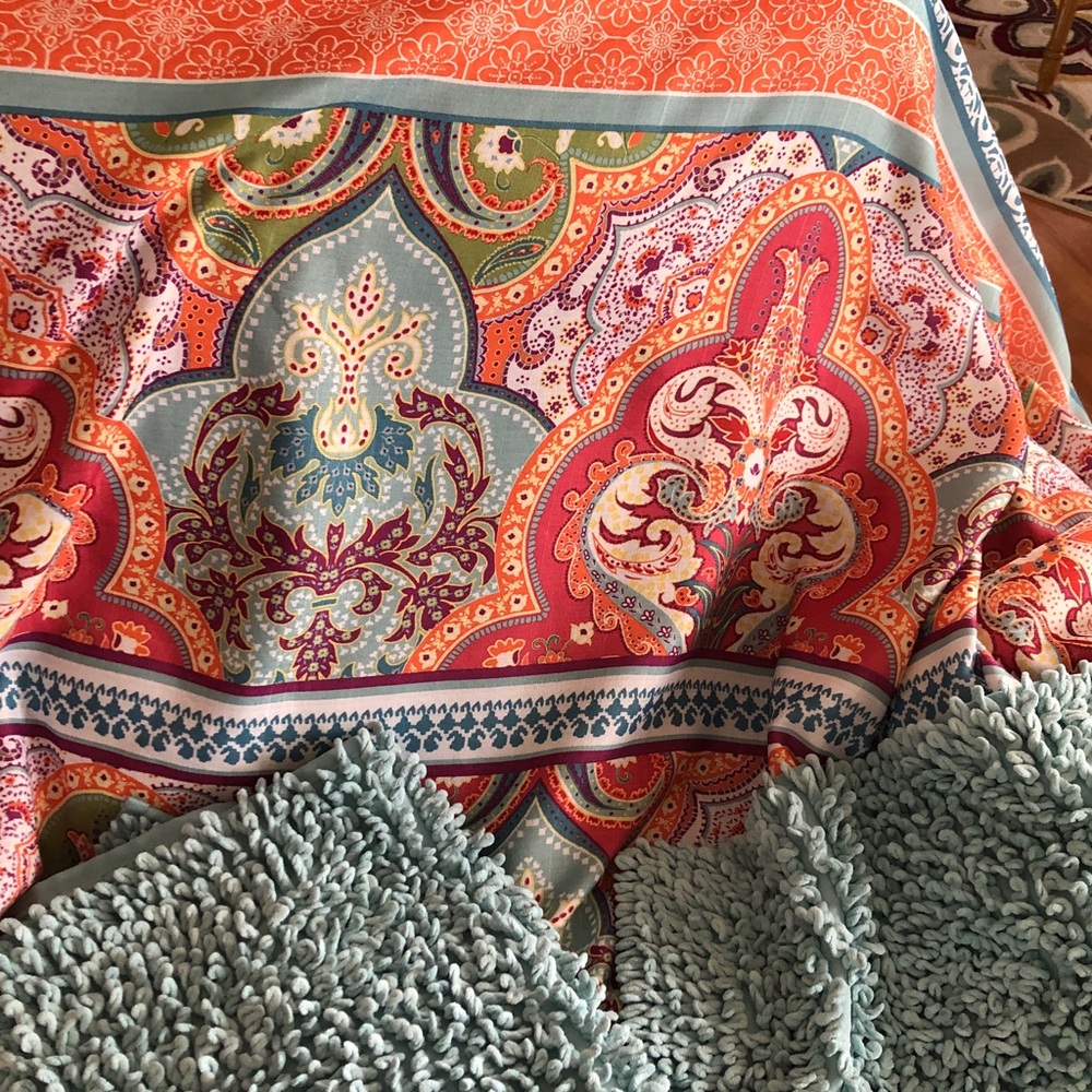 Multi-color shower curtain with matching rugs - teal, orange, pink, yellow.